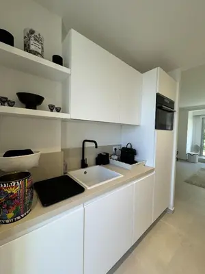 a kitchen with white cabinets and a sink at Apt moderne et luxueux a Cannes Res Miramar in Cannes