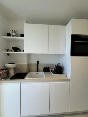 a kitchen with white cabinets and a sink at Apt moderne et luxueux a Cannes Res Miramar in Cannes
