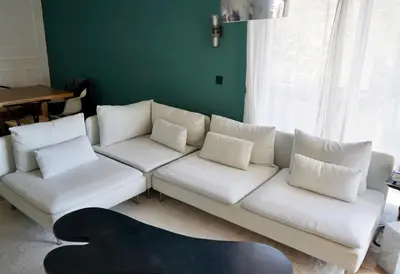 a living room with a white couch with pillows at T2 Appartement 55m2 Terrasse 20m2 - à 15min à pied du Centre Ville - Wifi - Air conditioning in Cannes