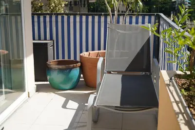 a chair sitting on a porch next to some plants at T2 Appartement 55m2 Terrasse 20m2 - à 15min à pied du Centre Ville - Wifi - Air conditioning in Cannes