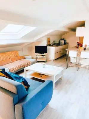 a living room with a blue couch and a table at CANNES CENTRE proche PLAGE CROISETTE PALAIS DES FESTIVALS in Cannes