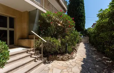 a house with stairs and flowers in front of it at Studio Fenelon terrasse et Parking Cannes in Cannes