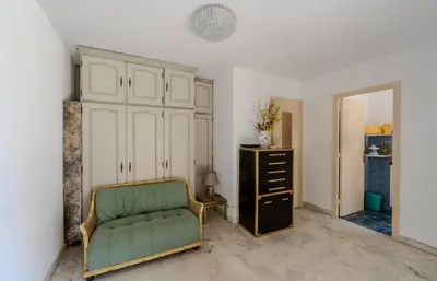 a living room with a green chair and a dresser at Studio Fenelon terrasse et Parking Cannes in Cannes