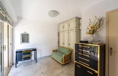 a living room with a green chair and a desk at Studio Fenelon terrasse et Parking Cannes in Cannes
