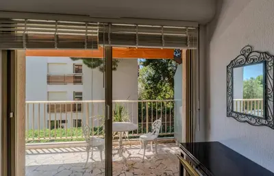 a balcony with a table and chairs and a mirror at Studio Fenelon terrasse et Parking Cannes in Cannes