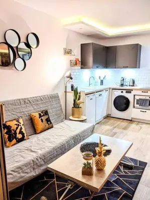 a living room with a couch and a kitchen at Centre Cannes 2-Bed Apt & garage 5min Croisette in Cannes