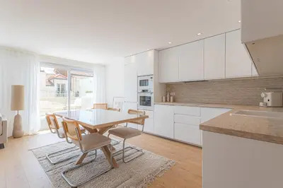 a kitchen with white cabinets and a table and chairs at Sublime 3 pièces entièrement rénové dans le centre de Cannes in Cannes