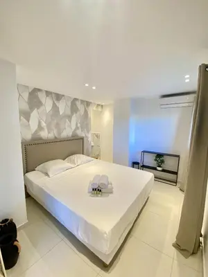 a bedroom with a large white bed with a tray on it at Appartement proche mer SC MACH in Cannes