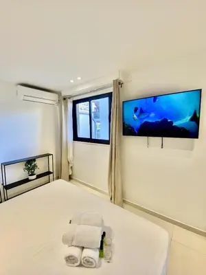 a bedroom with a bed with two towels and two televisions at Appartement proche mer SC MACH in Cannes