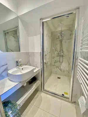 a white bathroom with a sink and a shower at Appartement proche mer SC MACH in Cannes
