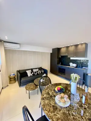 a living room with a table and a couch at Appartement proche mer SC MACH in Cannes