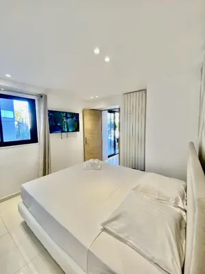 a large white bed in a room with a window at Appartement proche mer SC MACH in Cannes