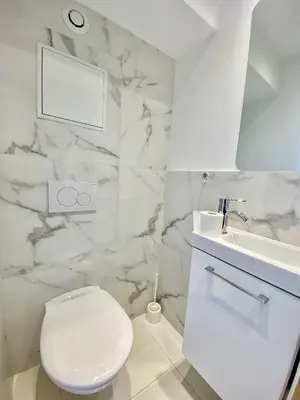 a white bathroom with a toilet and a sink at Appartement proche mer SC MACH in Cannes