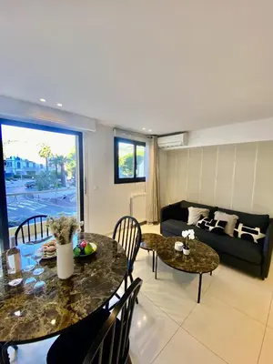 a living room with two tables and a couch at Appartement proche mer SC MACH in Cannes