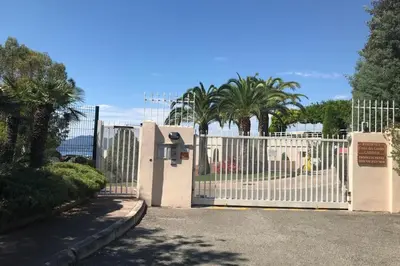 a white fence with a gate with palm trees at Le Seaview - Calm - Pool - Farniente - Sea view in Cannes