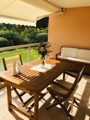 a wooden table and chairs on a patio at Le Seaview - Calm - Pool - Farniente - Sea view in Cannes