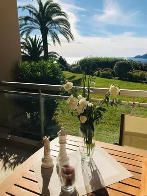 a vase of flowers on a table with a view at Le Seaview - Calm - Pool - Farniente - Sea view in Cannes