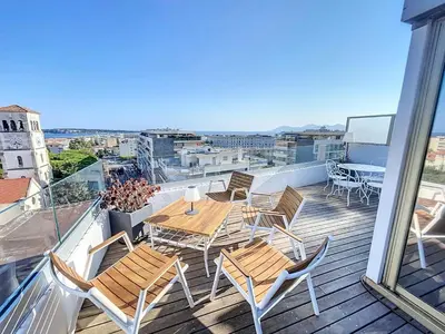a balcony with a table and chairs on a roof at Wow Splendide 3-4 pcs Duplex Rooftop Vue mer by Olam Properties in Cannes