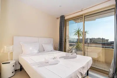 a bedroom with a white bed and a large window at Wow Splendide 3-4 pcs Duplex Rooftop Vue mer by Olam Properties in Cannes