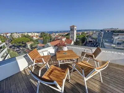 a patio with a table and chairs on a balcony at Wow Splendide 3-4 pcs Duplex Rooftop Vue mer by Olam Properties in Cannes