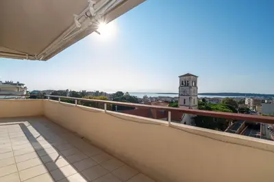 a balcony with a view of a clock tower at Wow Splendide 3-4 pcs Duplex Rooftop Vue mer by Olam Properties in Cannes