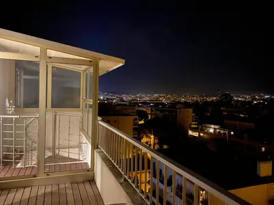 a balcony with a view of a city at night at Wow Splendide 3-4 pcs Duplex Rooftop Vue mer by Olam Properties in Cannes