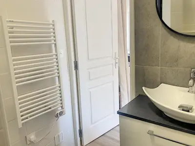 a bathroom with a white door and a sink at Carré d'Or F1bis Croisette 1 mn Olam Properties in Cannes