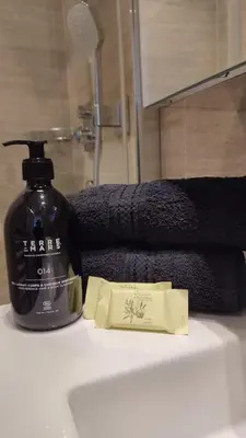 a bottle of soap sitting on a bathroom sink at Studio rénové, vue dégagée et arborée, 700m plage in Cannes