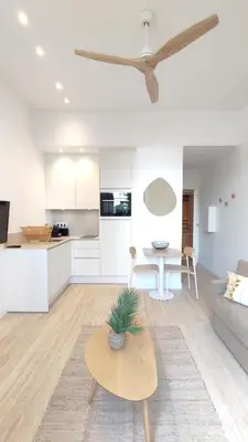 a living room with a couch and a table at Studio rénové, vue dégagée et arborée, 700m plage in Cannes