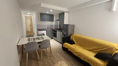 a living room with a yellow couch and a table at Studio à Cannes La Bocca in Cannes