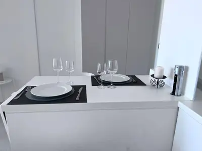 a white counter with two plates and wine glasses at Amazing sea view, parking, easy beach access in Cannes