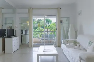 a white living room with a couch and a table at LE BELLA studio avec balcon idéal pour une évasion à deux, au calme et proche du centre-ville in Cannes