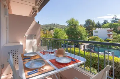 a table with plates and glasses on a balcony at LE BELLA studio avec balcon idéal pour une évasion à deux, au calme et proche du centre-ville in Cannes