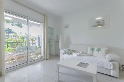 a white living room with a couch and a table at LE BELLA studio avec balcon idéal pour une évasion à deux, au calme et proche du centre-ville in Cannes