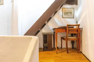 a table with a chair and a desk under a stairs at 