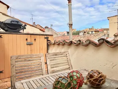 two chairs sitting on top of a balcony with a building at 