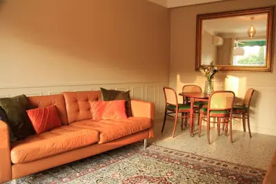 a living room with an orange couch and a table at Appartement Élégant avec Balcon Centre Cannes in Cannes