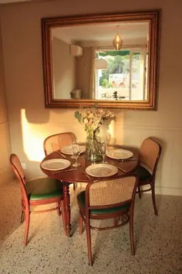 a dining room table with chairs and a vase of flowers at Appartement Élégant avec Balcon Centre Cannes in Cannes