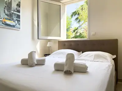 a bedroom with a white bed with towels on it at Charmant Studio avec terrasse et vue arborée in Cannes