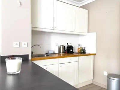 a kitchen with white cabinets and a counter top at Charmant Studio avec terrasse et vue arborée in Cannes