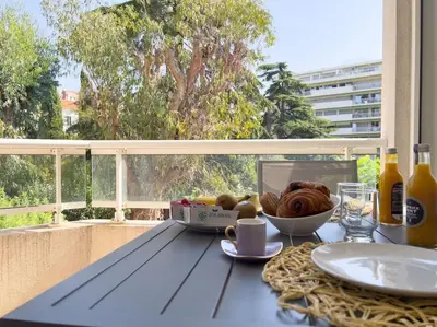 a table with a bowl of bread and a plate of food at Charmant Studio avec terrasse et vue arborée in Cannes