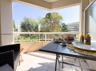 a table with a plate of food on a balcony at Charmant Studio avec terrasse et vue arborée in Cannes