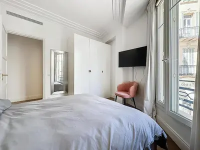 a bedroom with a bed and a tv and a chair at INTUITION - 2 pieces - Cannes Carre d or in Cannes