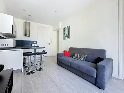 a living room with a couch and a kitchen at Intuition 2 lits 2'' Croisette et Palais des Festivals in Cannes