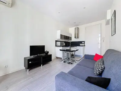a living room with a blue couch and a tv at Intuition 2 lits 2'' Croisette et Palais des Festivals in Cannes