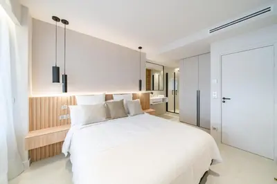 a bedroom with a large white bed and a bathroom at Beautiful 3 bedroom fully renovated in Cannes