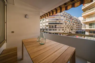 two glass vases sitting on a wooden table on a balcony at Beautiful 3 bedroom fully renovated in Cannes