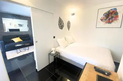 a small bedroom with a bed and a couch at Cosy 2 pièces - Palais Croisette Cannes in Cannes