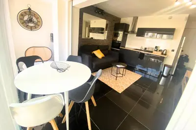 a kitchen and a living room with a table and chairs at Cosy 2 pièces - Palais Croisette Cannes in Cannes
