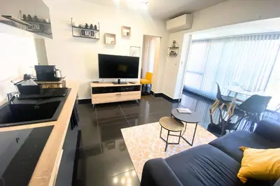 a living room with a blue couch and a tv at Cosy 2 pièces - Palais Croisette Cannes in Cannes